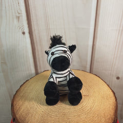 A black and white stripped zebra that is 5 inches tall while sitting