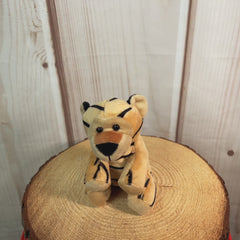 A stripped tiger that is 13 inches tall while sitting