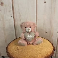 7 inch dusty pink stuffed bear holding a stuffed heart that says, "I love you".