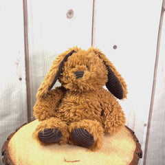 A white and brown scruffy rabbit that are 13 inches tall while standing with corduroy ears and feet