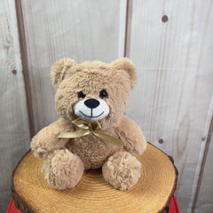 A beige bear that is 7 inches tall while sitting wearing a matching bow