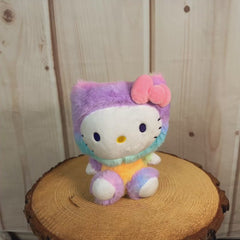 Stuffed Hello Kitty wearing a fuzzy rainbow tie died outfit with a pink bow on her ear