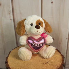 10 inch cream colored stuffed puppy holding a stuffed pink heart that says, "xoxo."