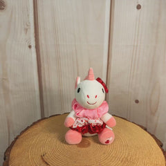 6" stuffed white unicorn keychain with three Valentine's designed hair scrunchies tied around its body