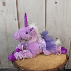 Purple stuffed unicorn wearing a purple tutu