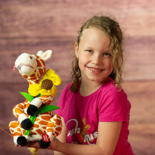 girl holding 12 in stuffed singing giraffe holding a flower