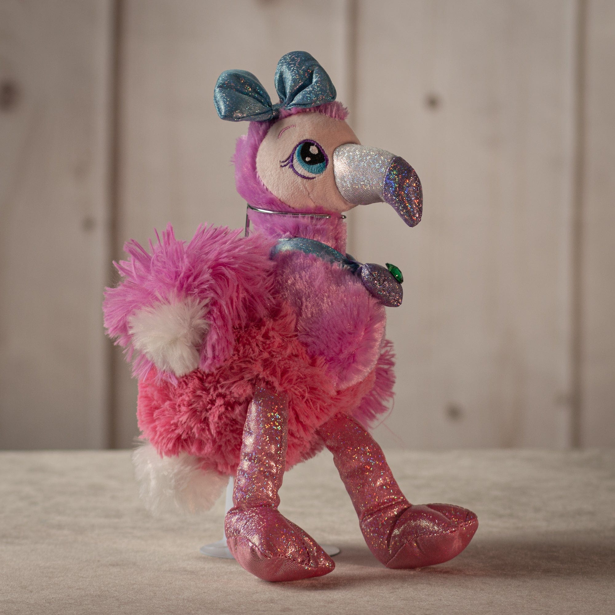 8" glamorous pink flamingo with sparkly legs, a diamond necklace, and a sparkly blue bow