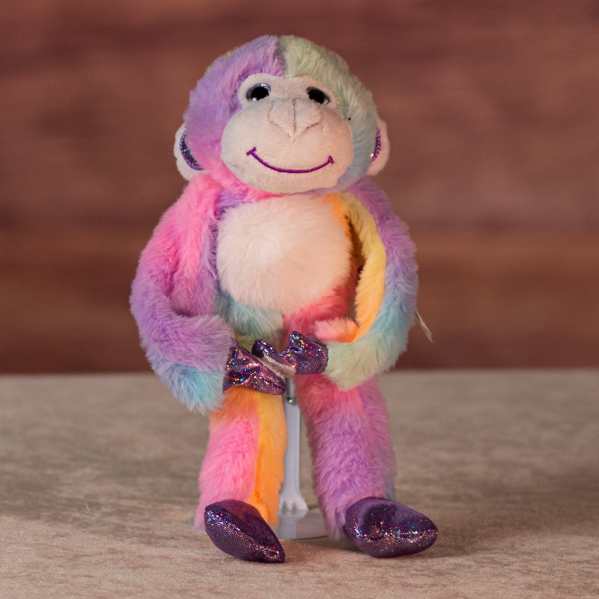 6 in rainbow sherbet monkeywith purple glitter hands and feet