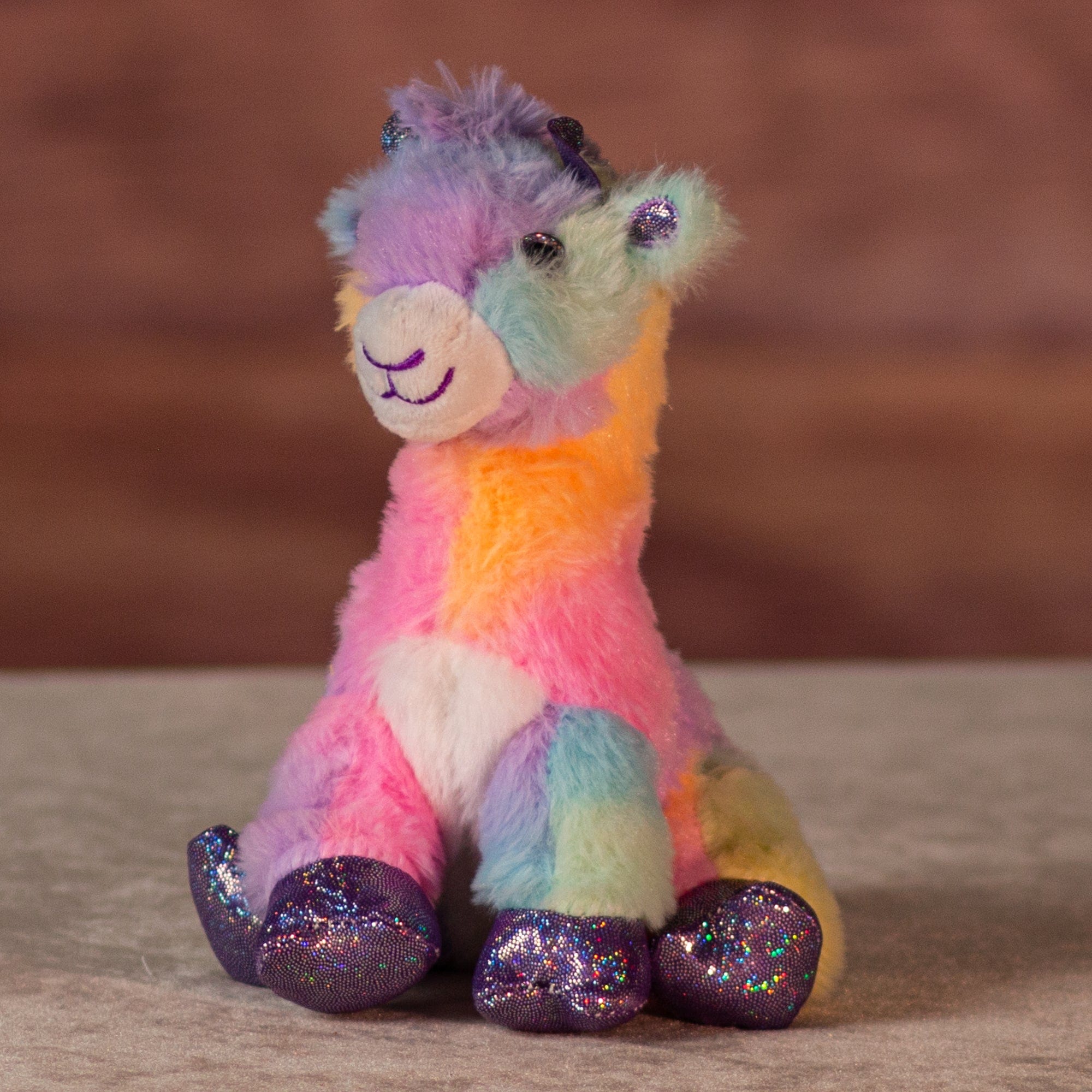 6 in rainbow sherbet giraffe with purple glitter hands and feet