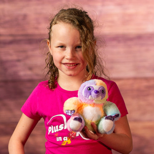 girl holding 6 in rainbow sherbet sloth with purple glitter hands and feet