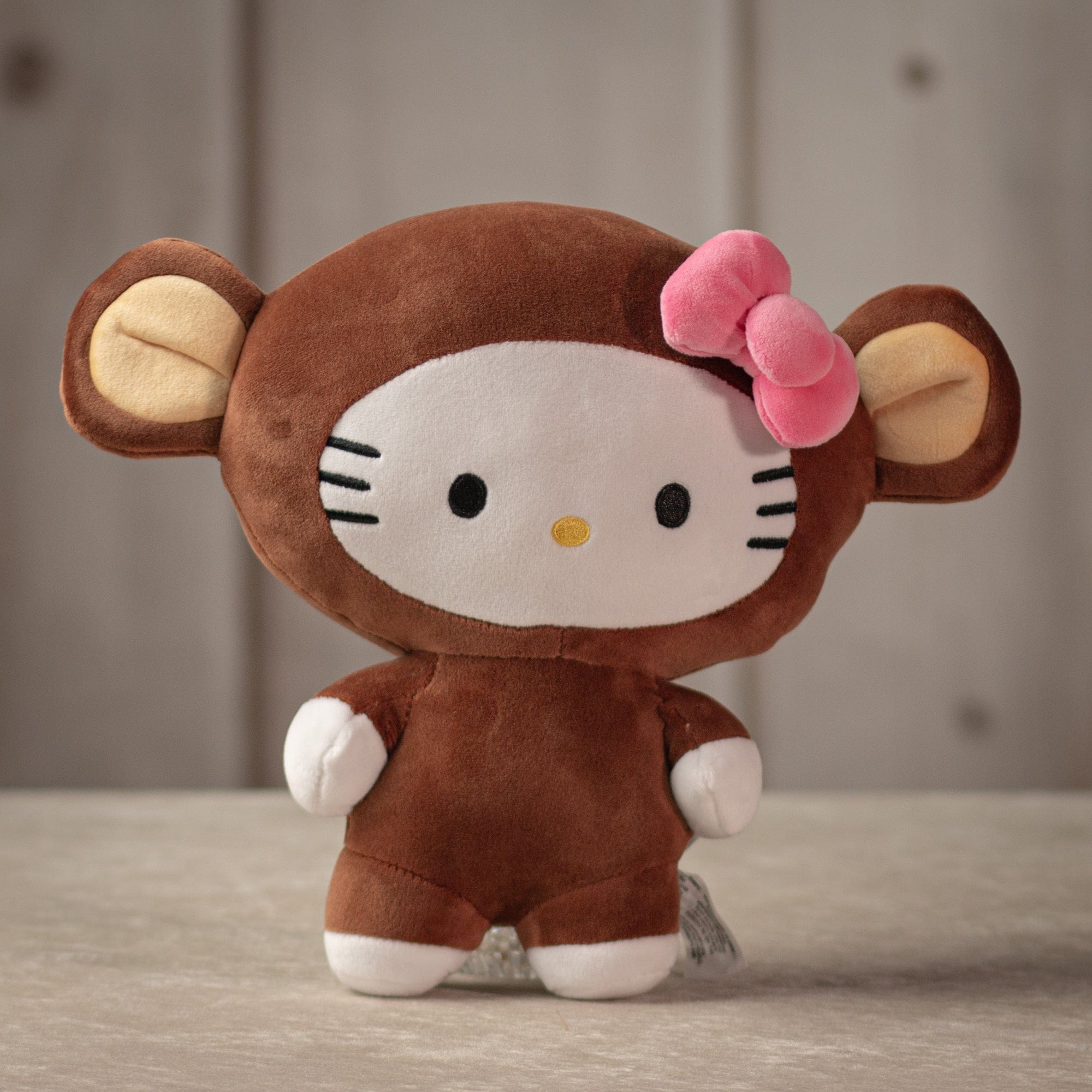 hello kitty in a monkey costume wearing a pink bow