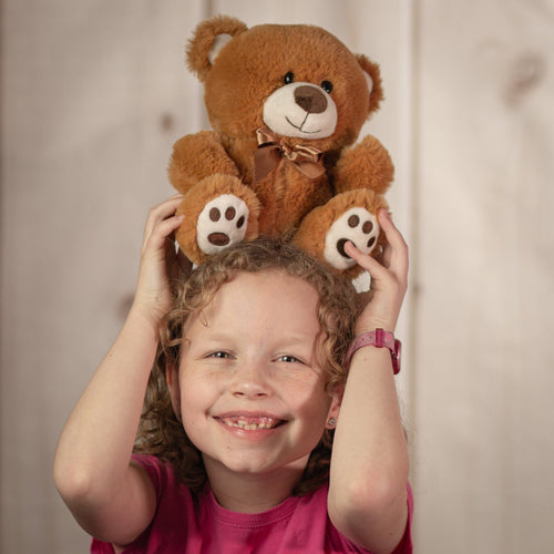 girl holding 8" Small and Friendly Bear holding a small brown bear wearing a bow