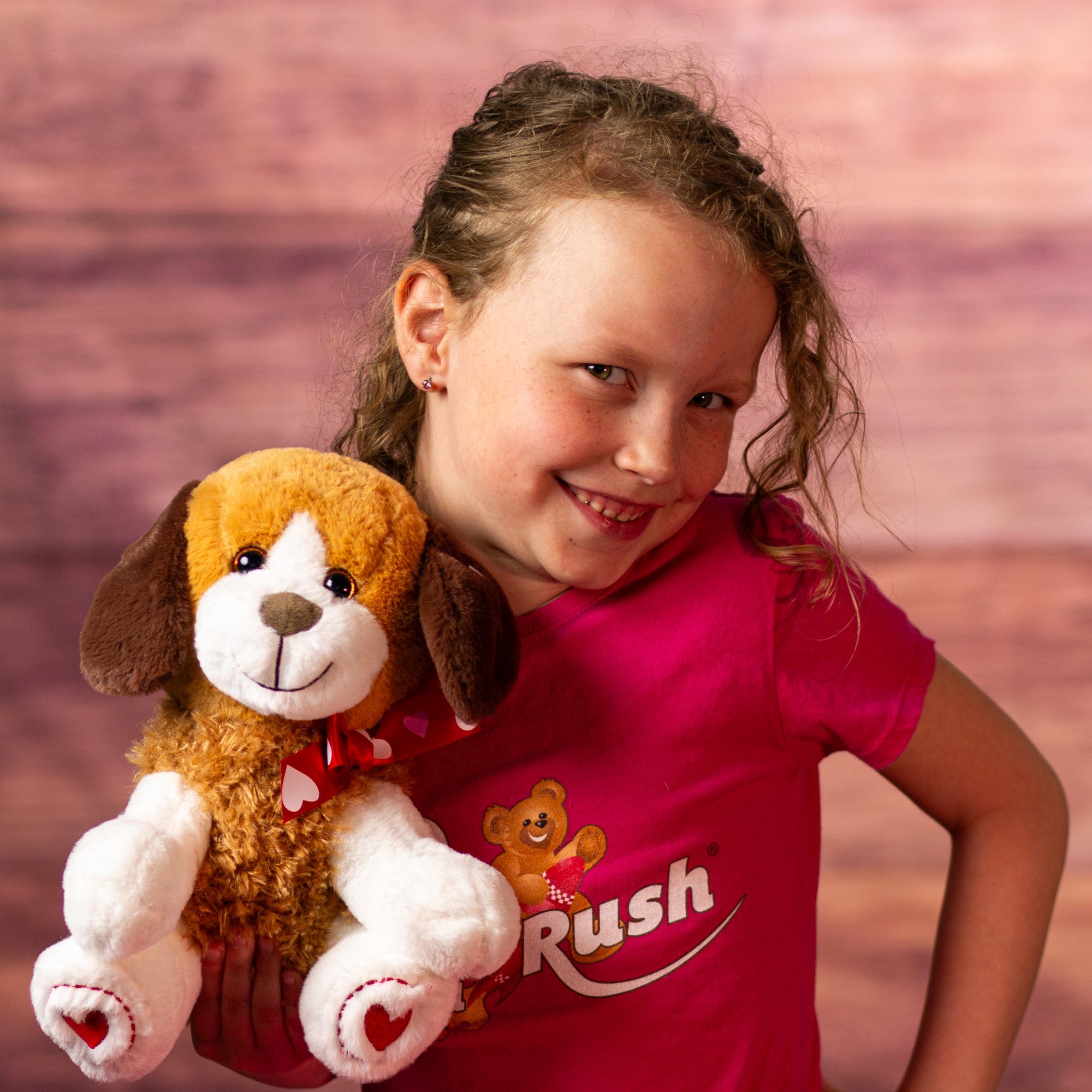 girl holding stuffed 10 in puppy wearing a heart bow and heart paws