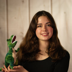 girl holding 9" green T-Rex with white teeth