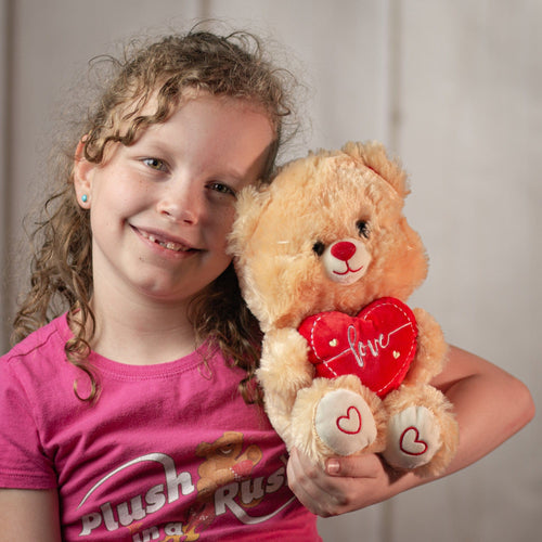 girl holding stuffed 9" tan valentines teddy bear with red love heart and red heart paws