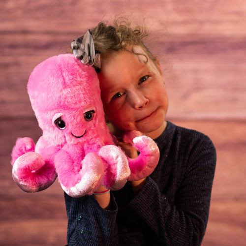 Kid holding pink octopus with bow and eyelashes