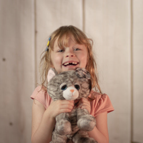 girl holding 10" Gray Bella Tabby Cat with a boy and sparkly blue eyes and eyelashes