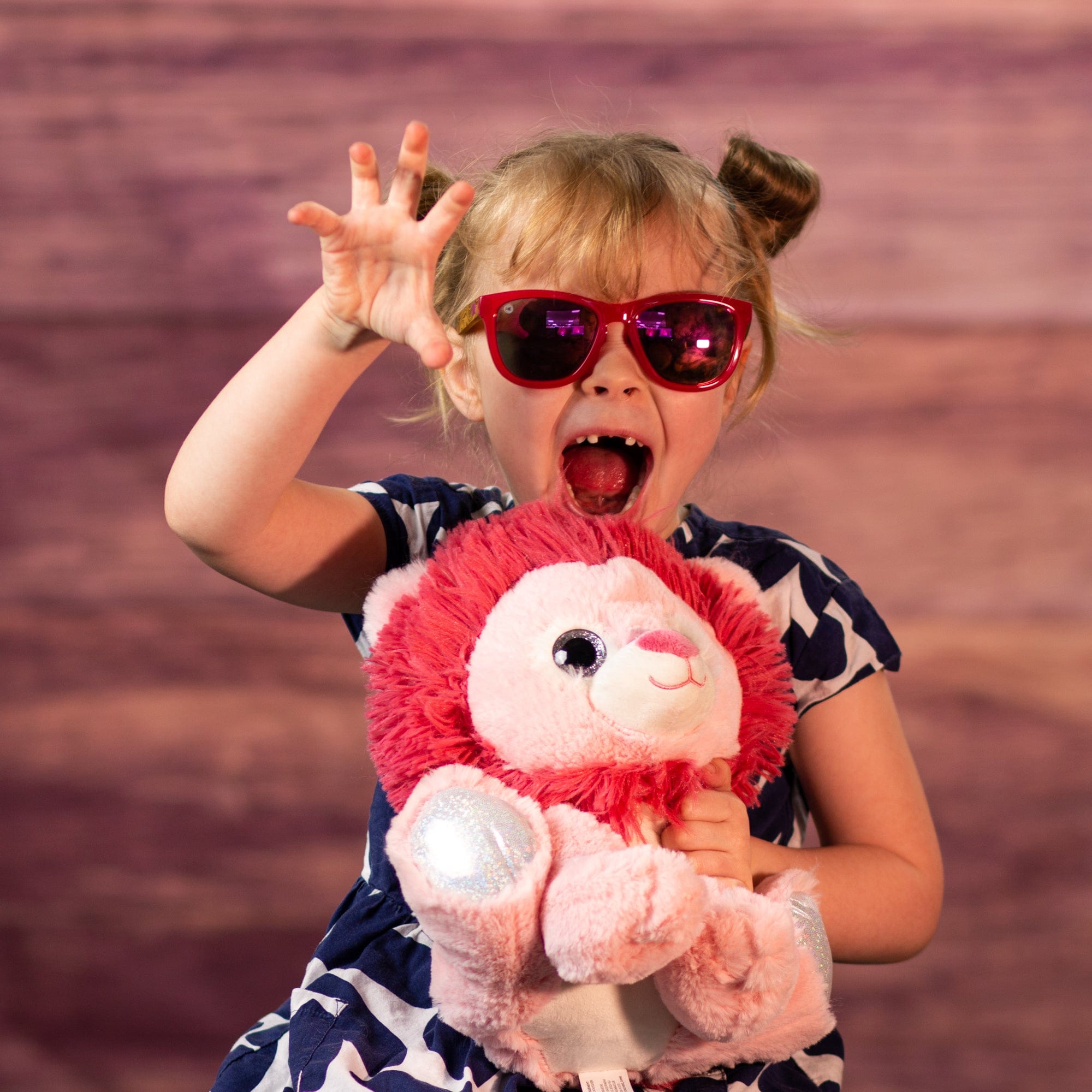 girl holding 10 in stuffed pink lion with glitter eyes and glitter ears and paws