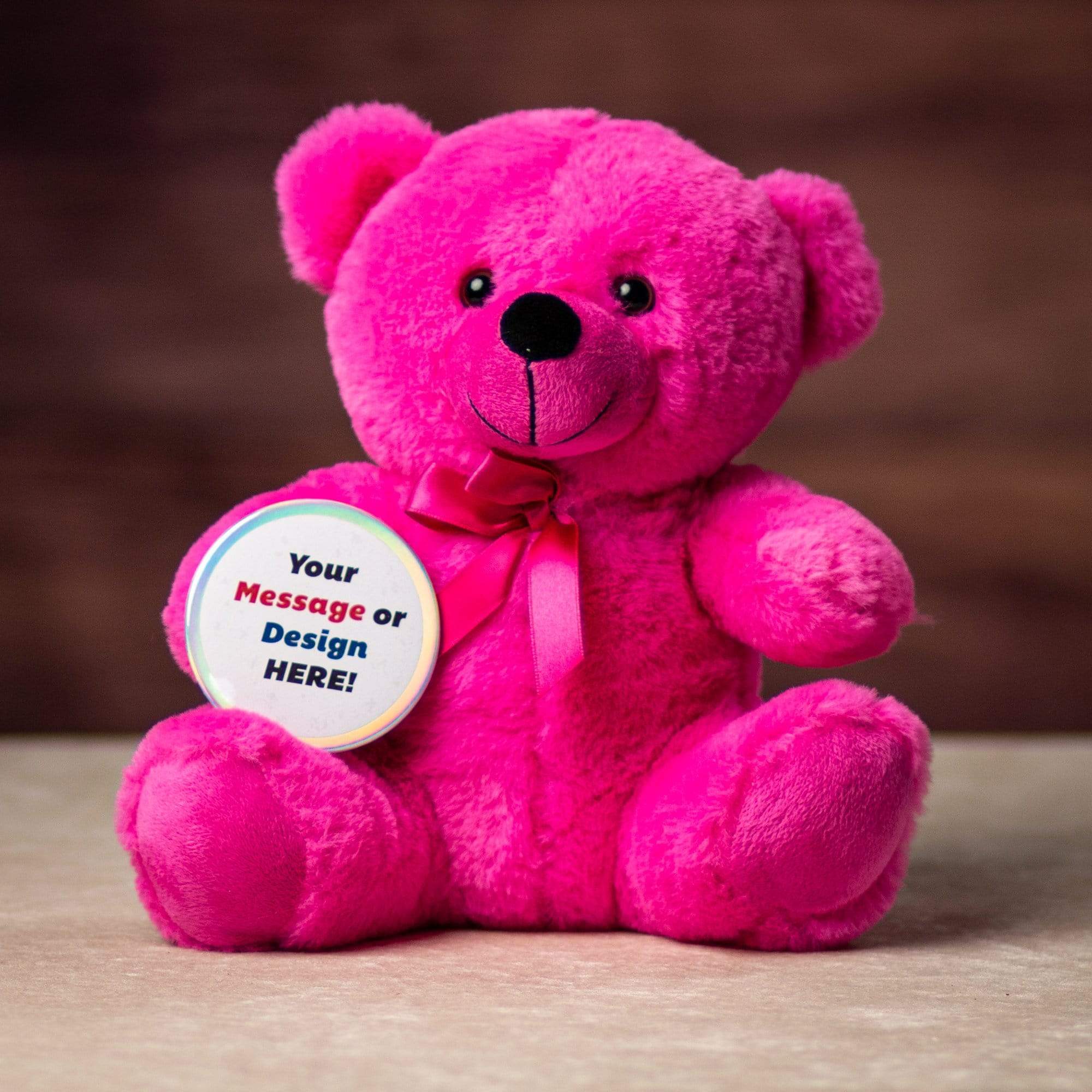 A pink bear holding a rainbow button