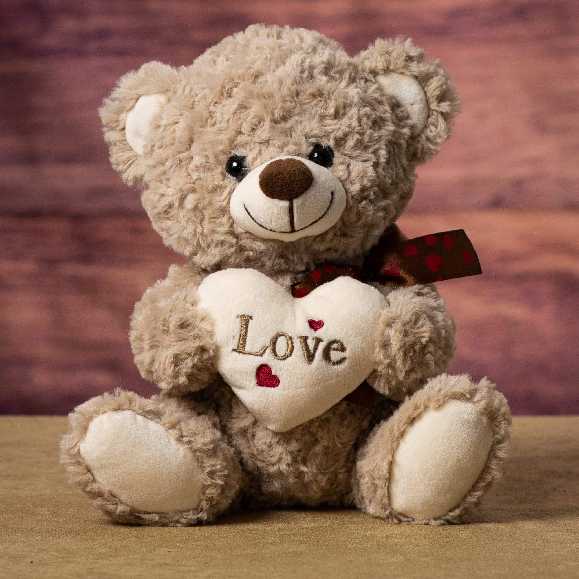 A brown bear that is 10 inches tall while sitting holding a cream Love heart