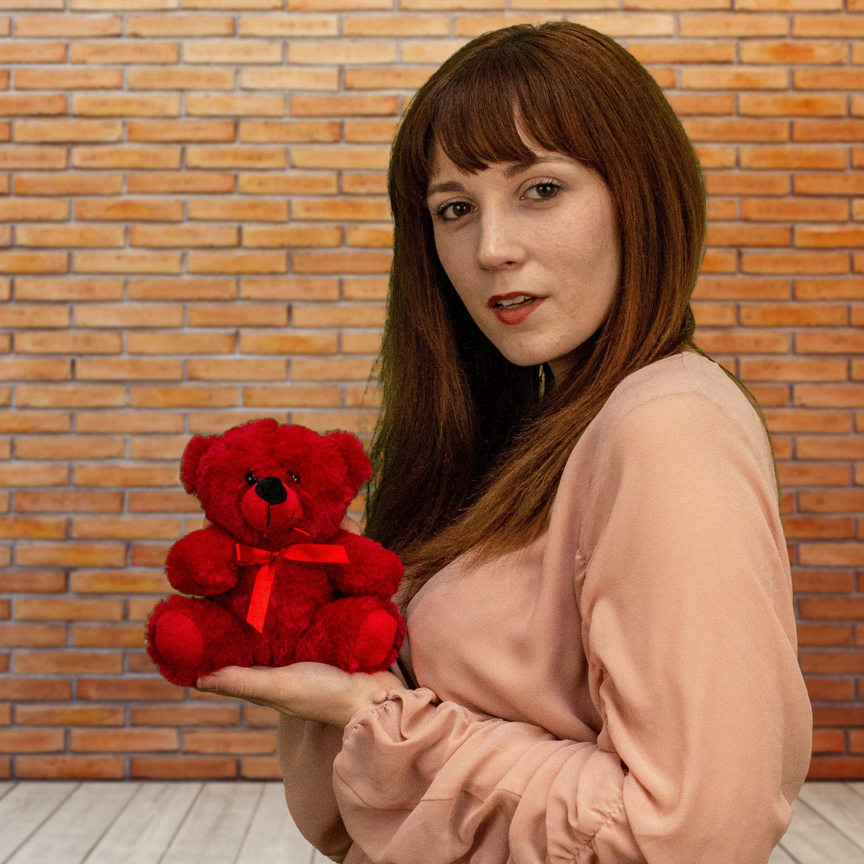 A woman holds a red bear that is 6 inches tall while sitting