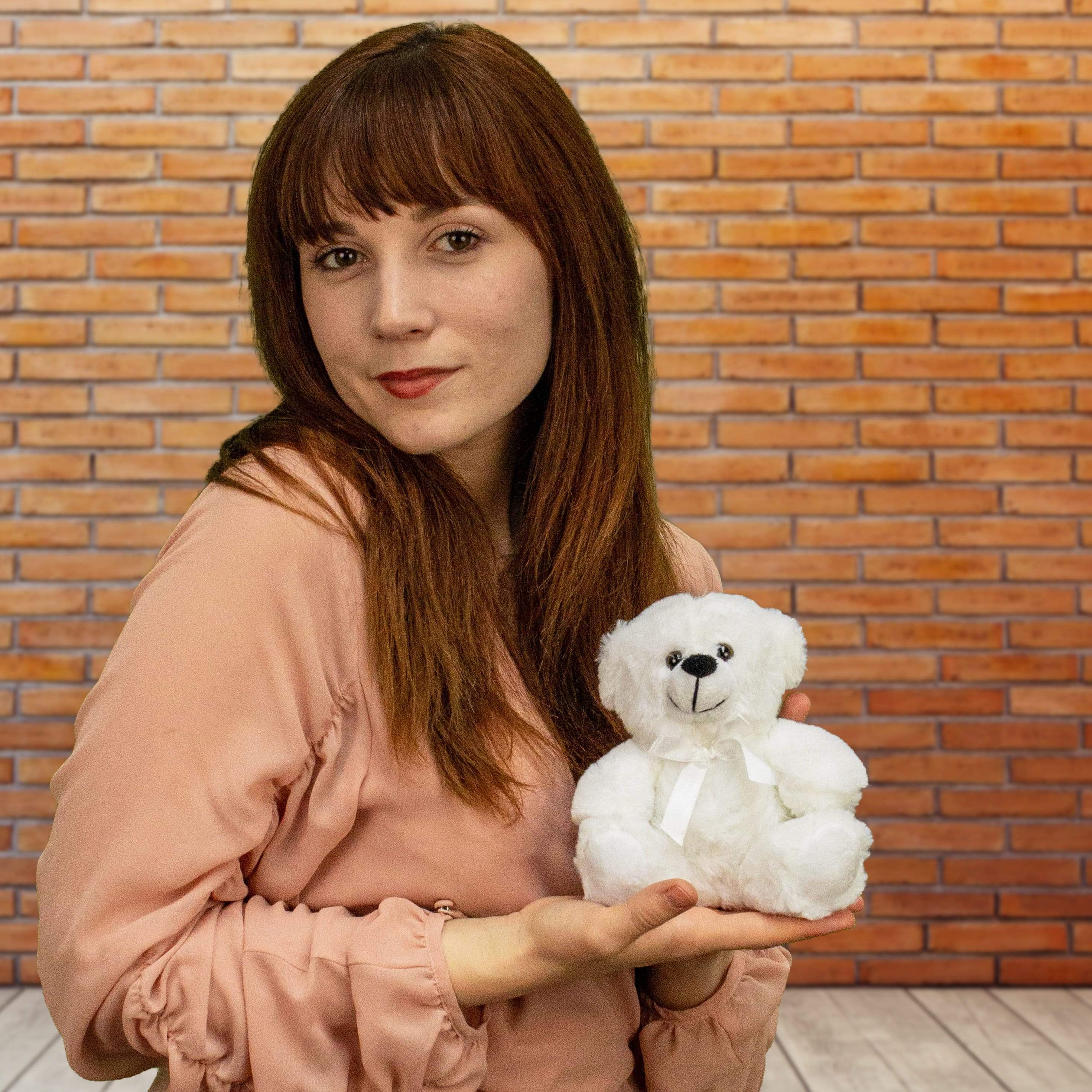 A woman holds a white bear that is 6 inches tall while sitting