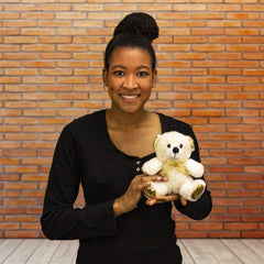 A woman holds a white bear that is 6 inches tall while sitting