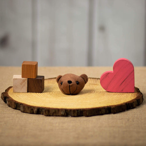 A brown bears head that is 3 inches from top to bottom on top of a piece of wood