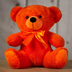 A orange bear that is 14 inches tall while sitting wearing a matching bow