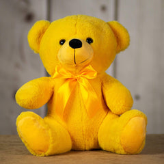 A yellow bear that is 14 inches tall while sitting wearing a matching bow