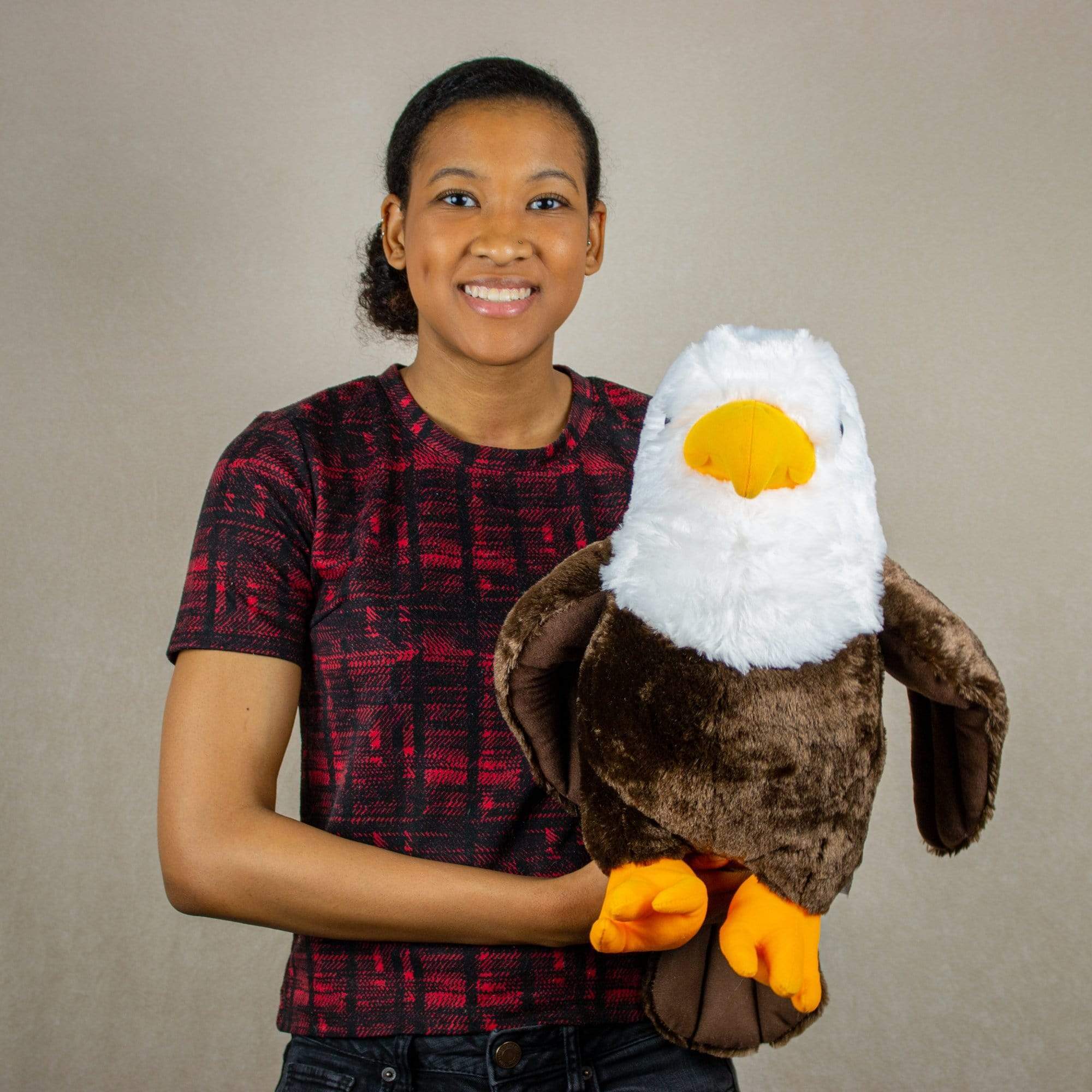 A woman holds a eagle that is 15 inches tall while standing