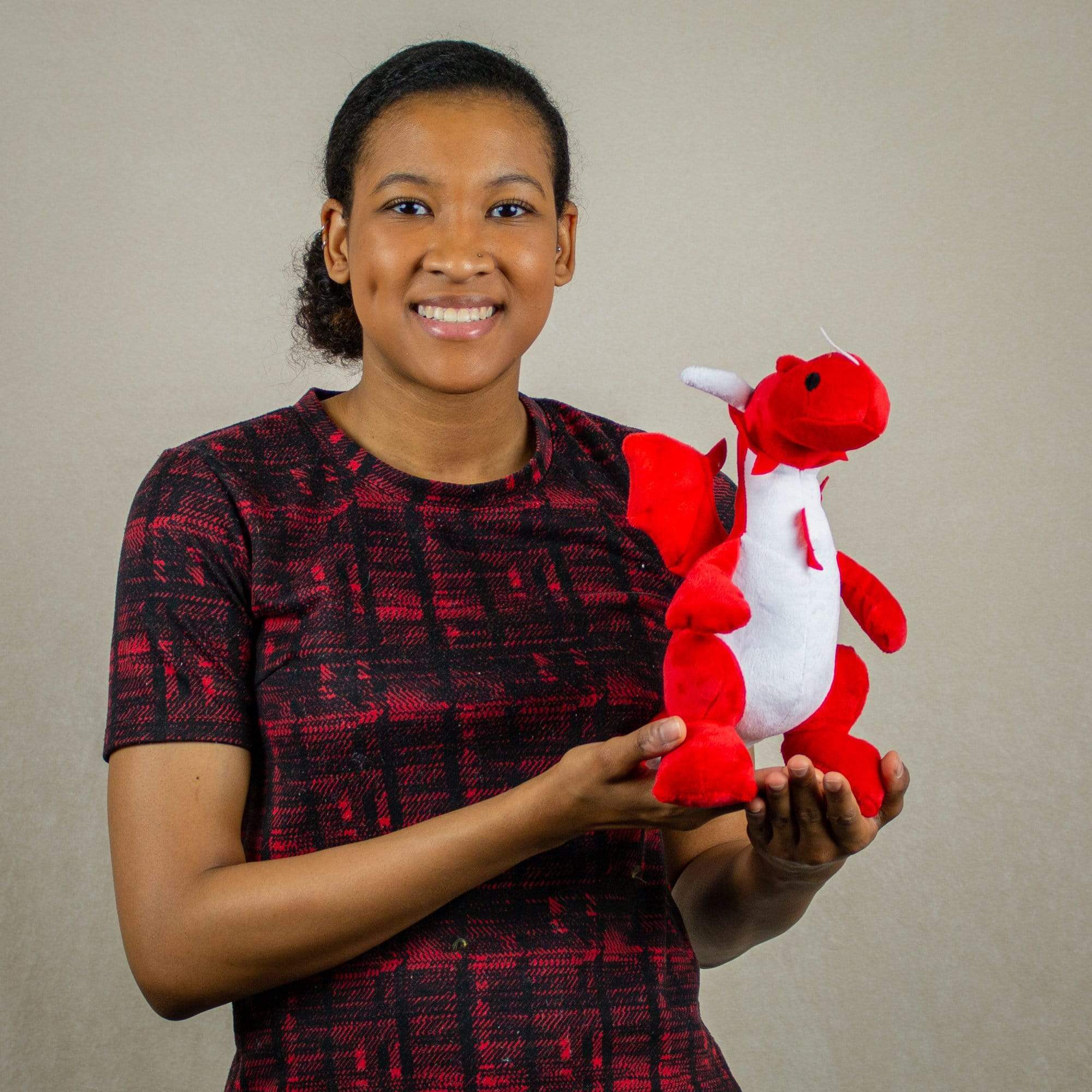 A woman holds a red dragon that is 10 inches tall while sitting