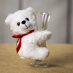 A white bear that is 5.5 inches tall while sitting hugging a vase