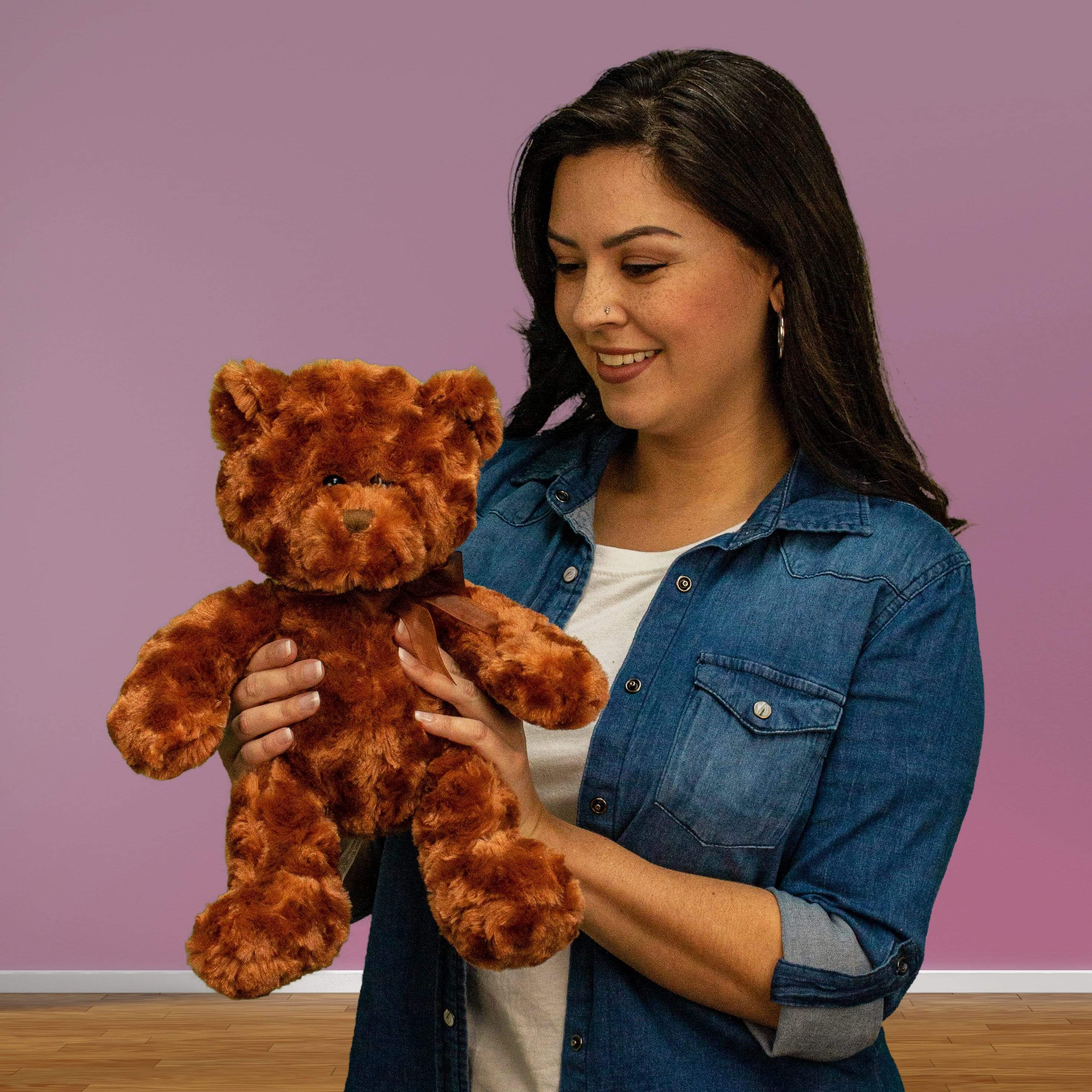 A woman holds a brown bear that is 14 inches tall while standing