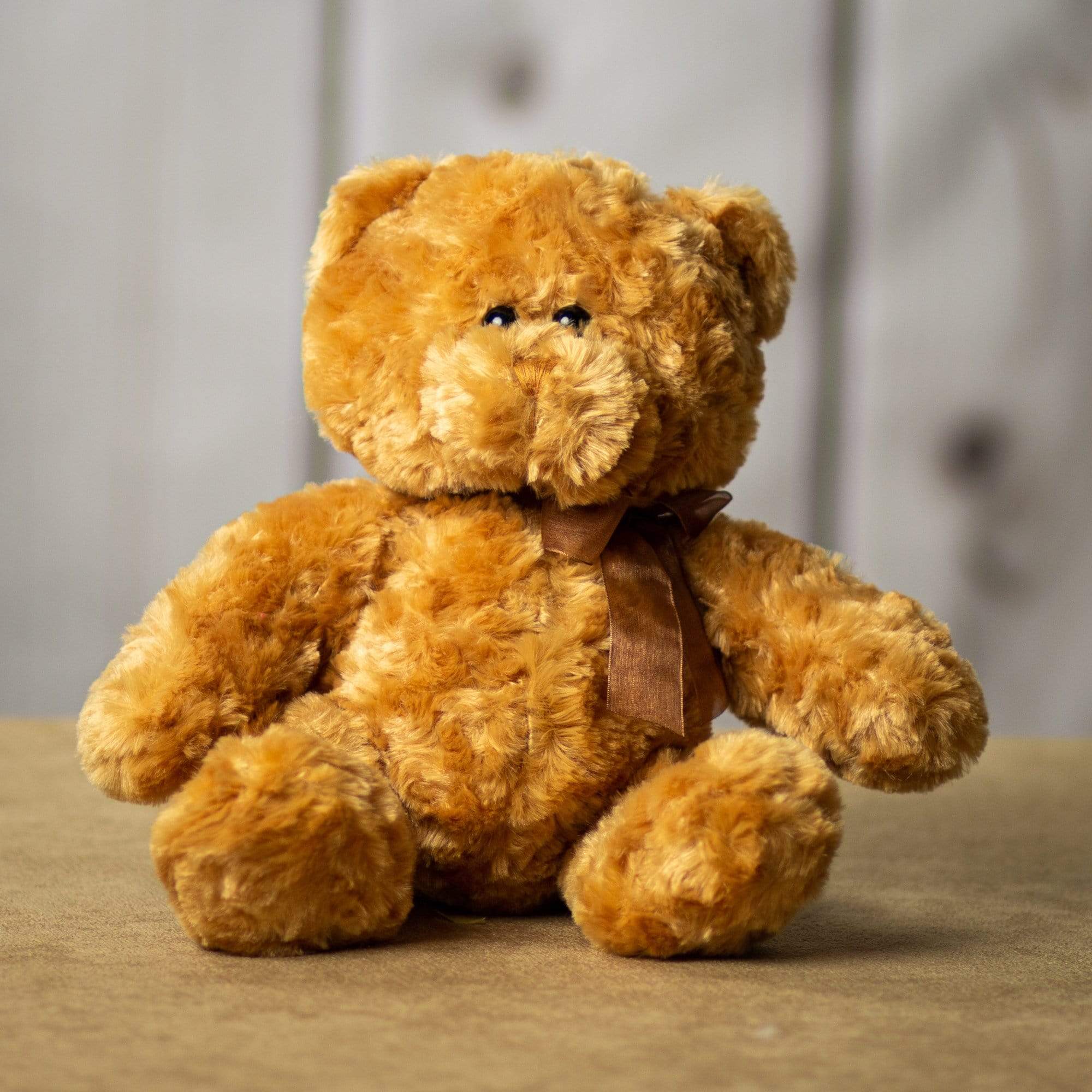 A beige bear that is 14 inches tall while standing in a sitting position