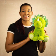 A woman holds a green triceratops that is 10.5 inches tall while sitting