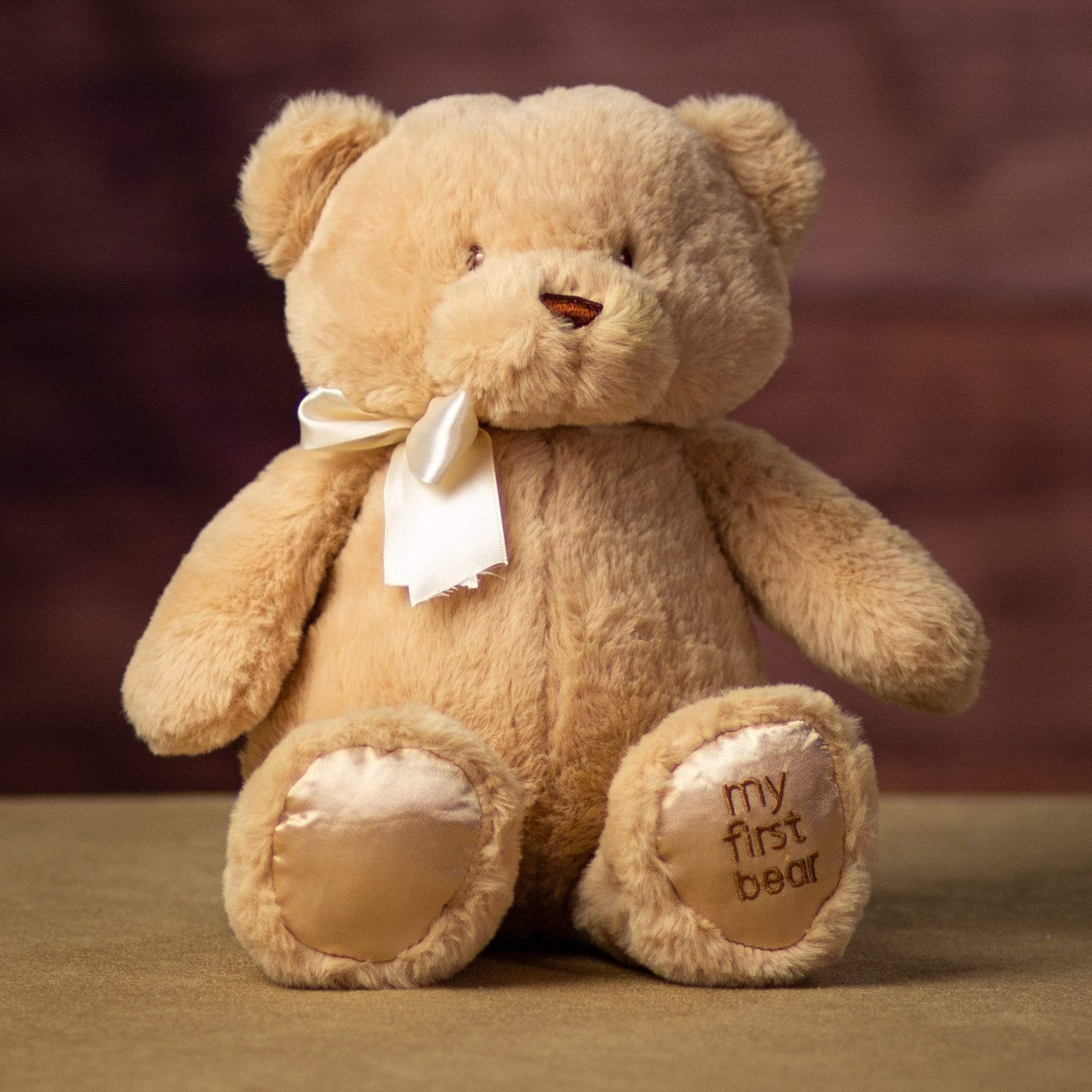 A sitting beige bear that is 15 inches tall while standing with "My First Bear" on its left paw