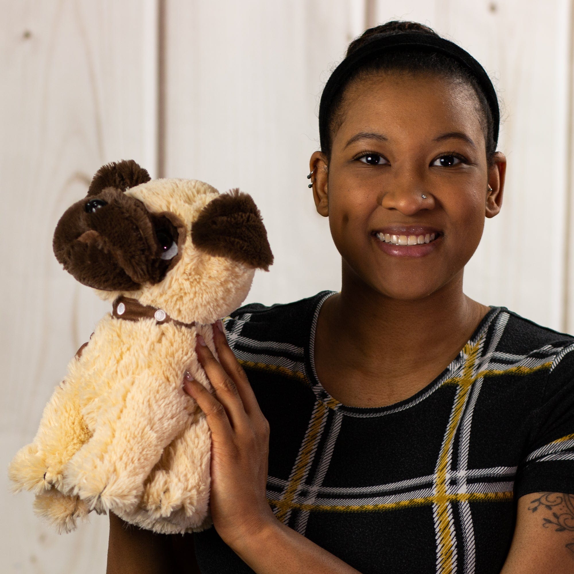 A woman holding a brown pug that is 11 inches tall while sitting