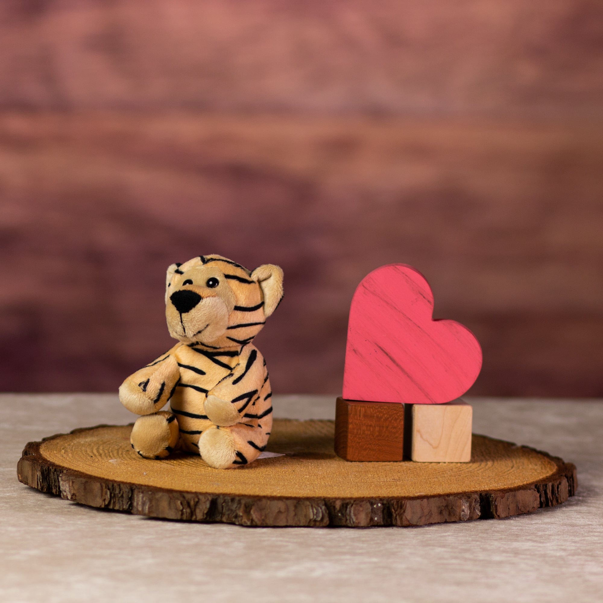 A stripped tiger that is 13 inches tall while sitting next to wooden blocks