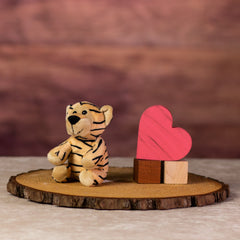 A stripped tiger that is 13 inches tall while sitting next to wooden blocks