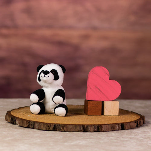 A black and white panda that is 5 inches tall while sitting next to wooden blocks