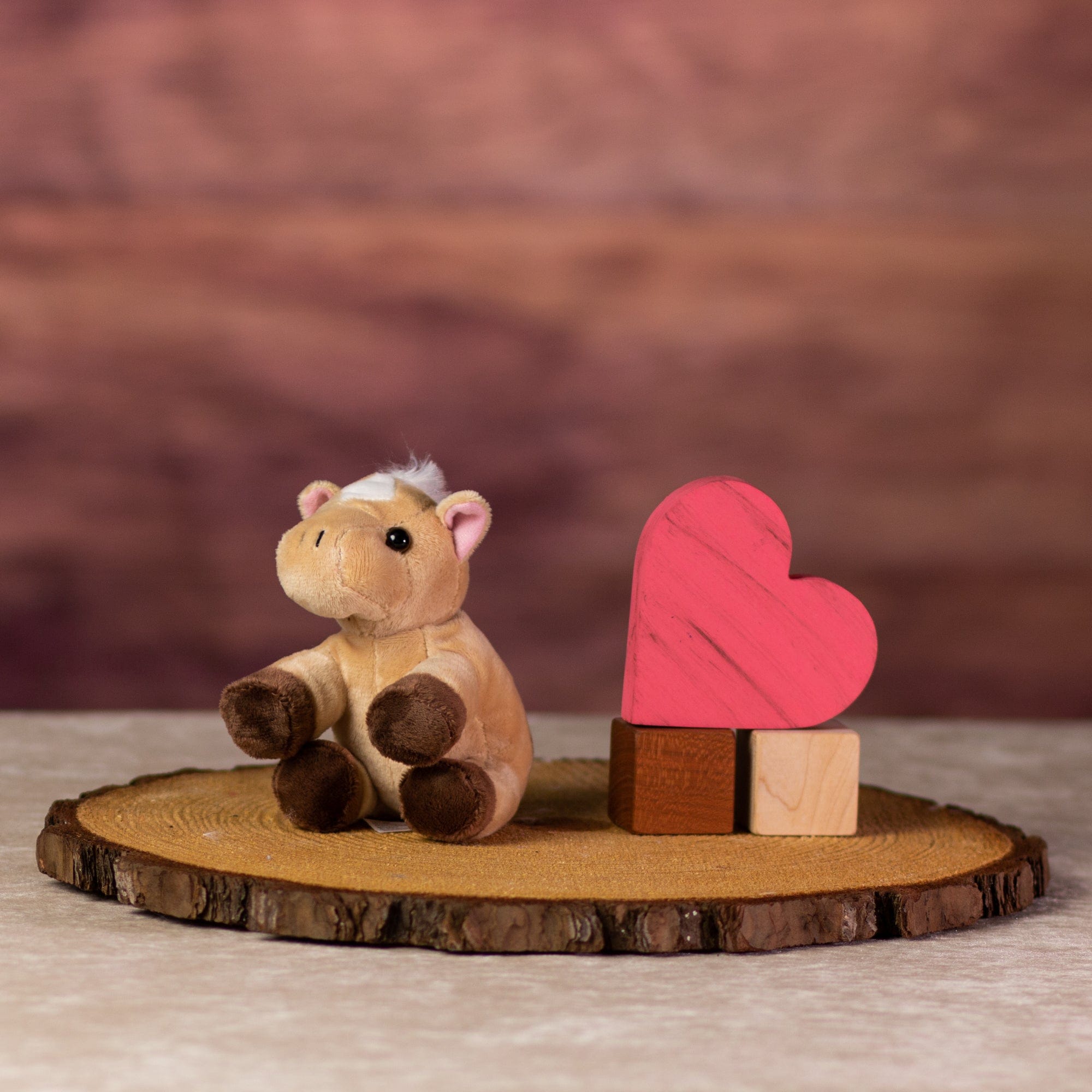 A beige horse that is 5 inches tall while sitting next to wooden blocks