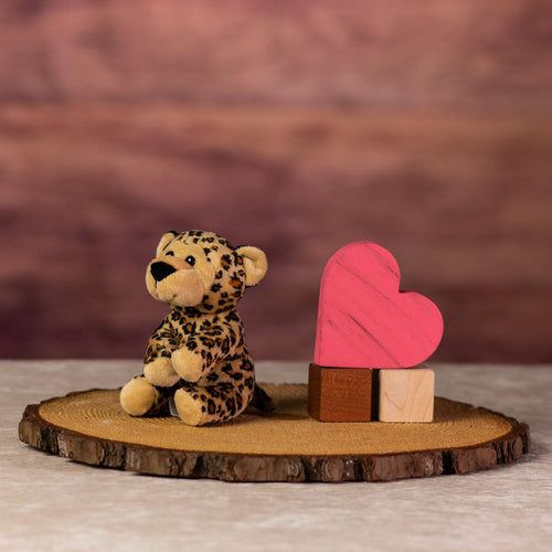 A spotted leopard that is 5 inches tall while sitting next to wooden blocks