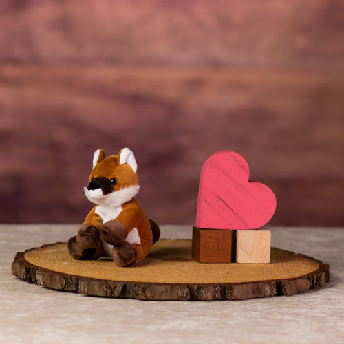 A orange fox that is 5 inches tall while sitting next to wooden blocks