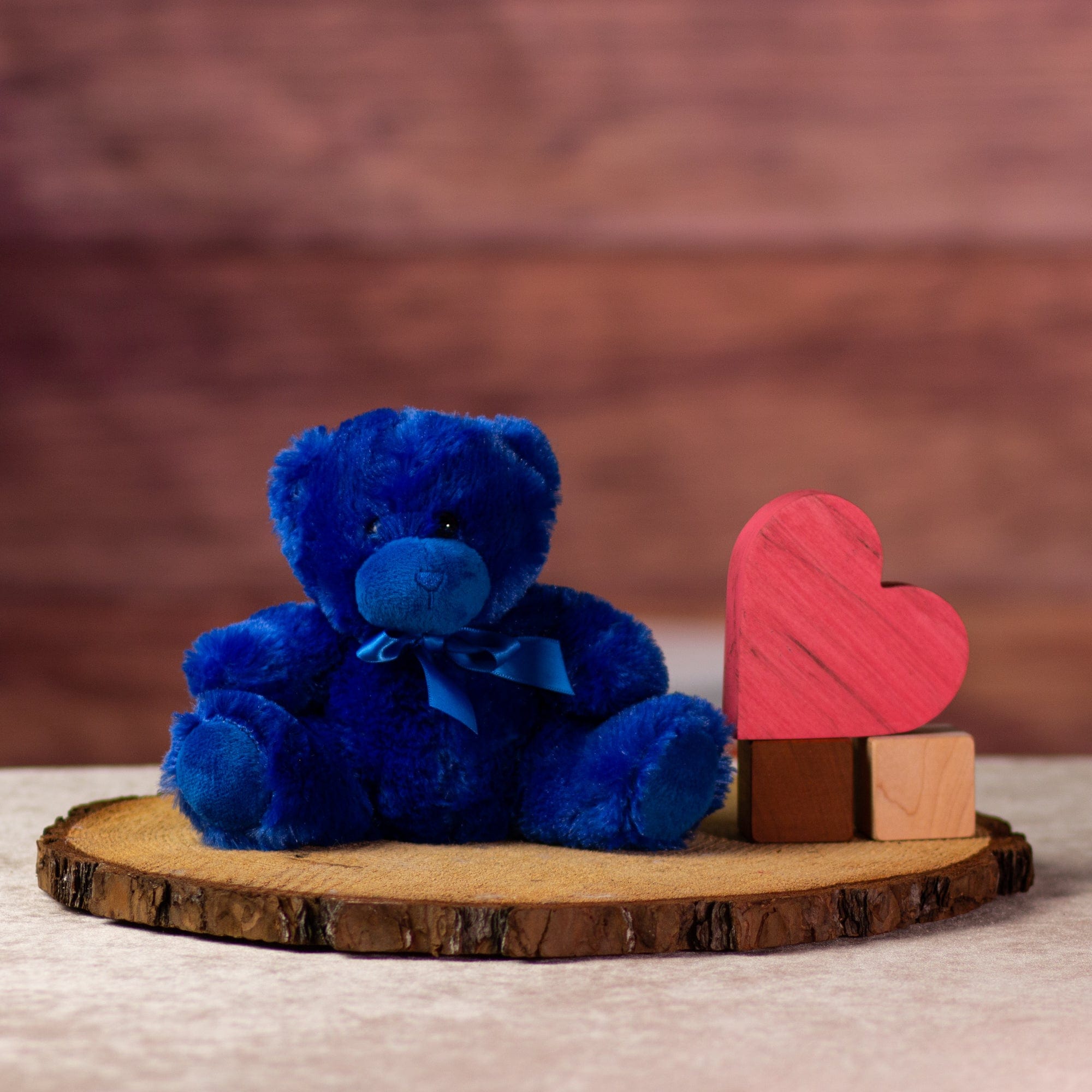 stuffed 6 in blue bright and cheery bear with bow around her neck