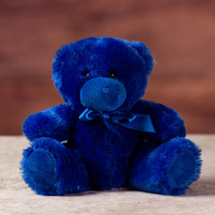 stuffed 6 in blue bright and cheery bear with bow around her neck