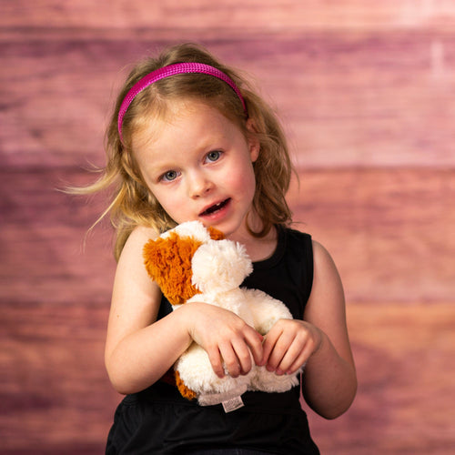 girl holding 7 in stuffed small furry bulldog