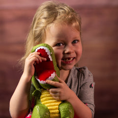 A girl holding a green dinosaur that is 9.5 inches tall while standing