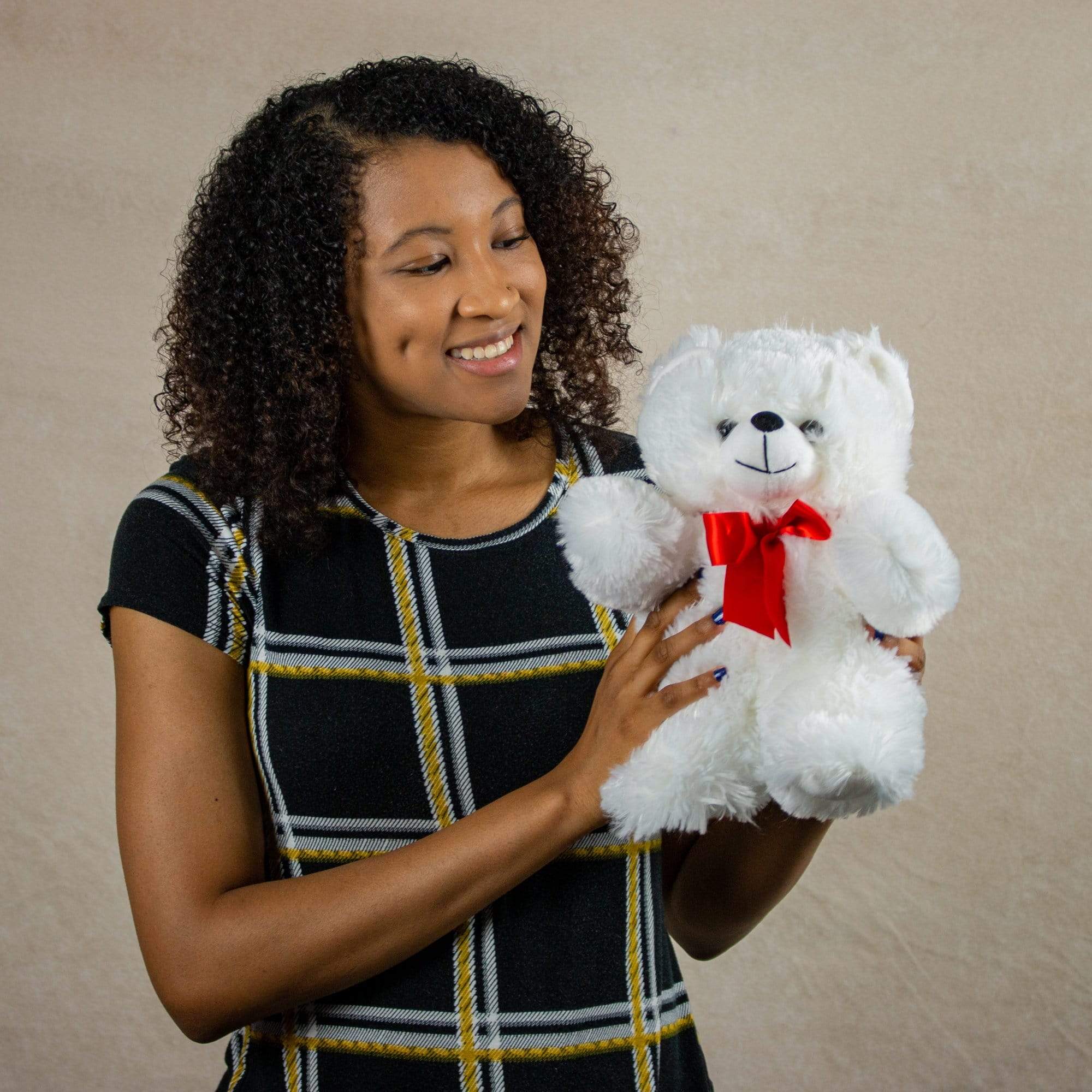 A woman holds a white bear that is 11 inches tall while standing