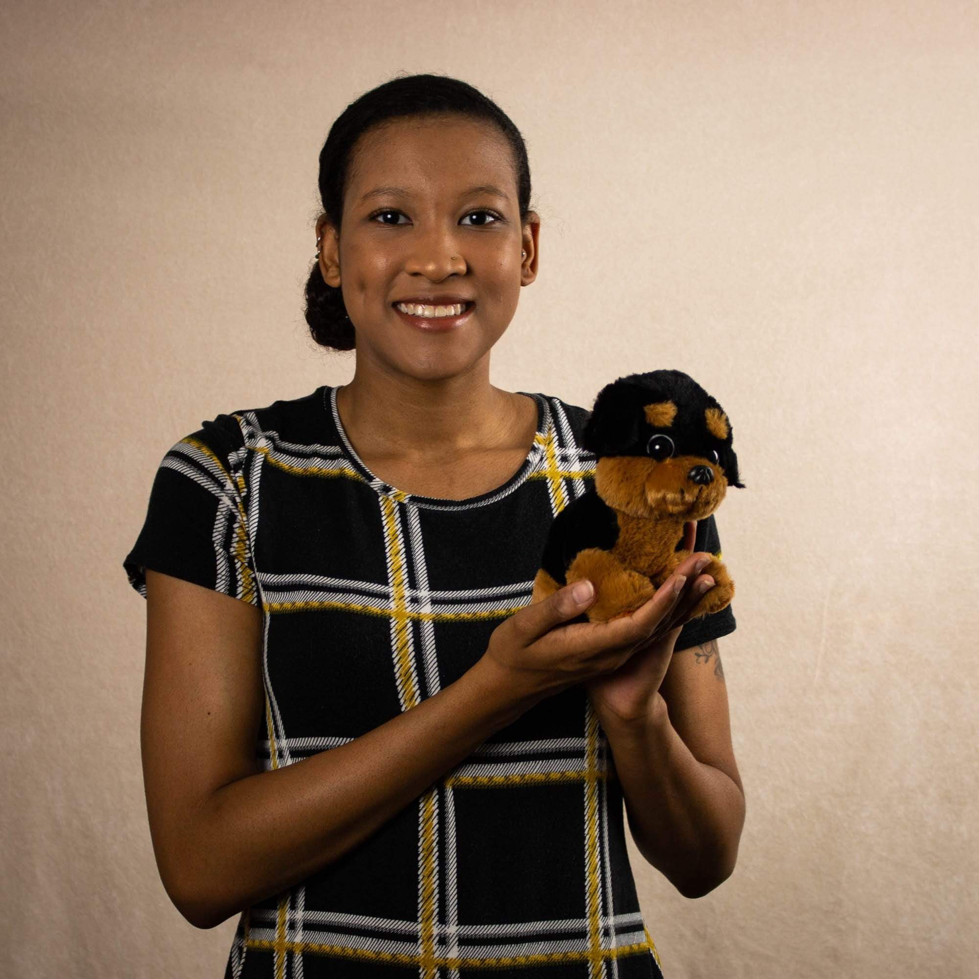 A woman holds a black and brown puppy that is 7 inches tall while sitting